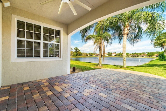 view of patio featuring ceiling fan and a water view