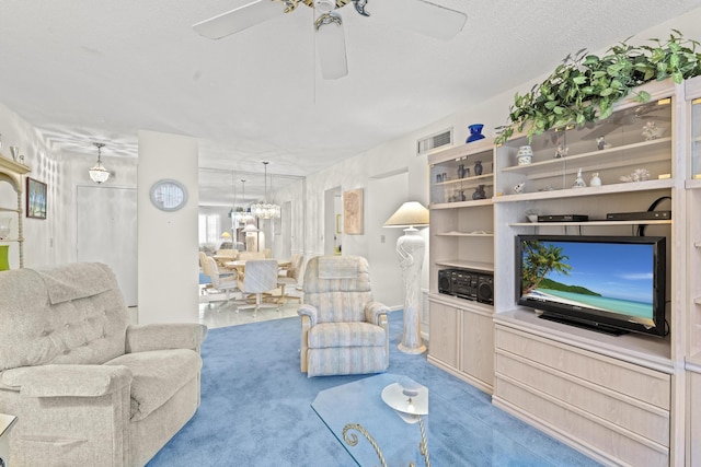 living room with carpet flooring, ceiling fan, and a textured ceiling