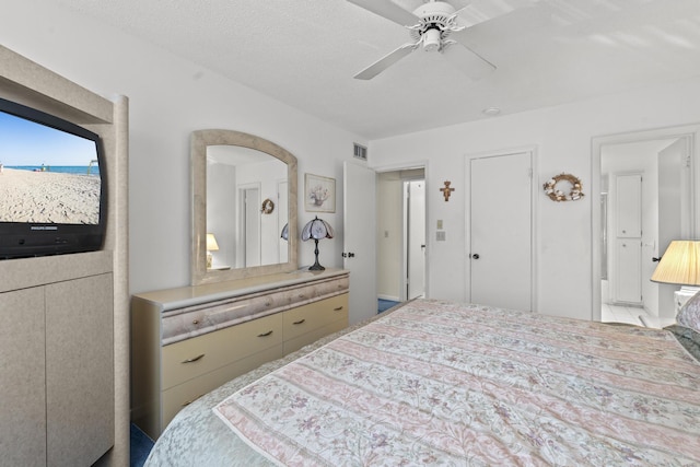 bedroom featuring ceiling fan and a textured ceiling