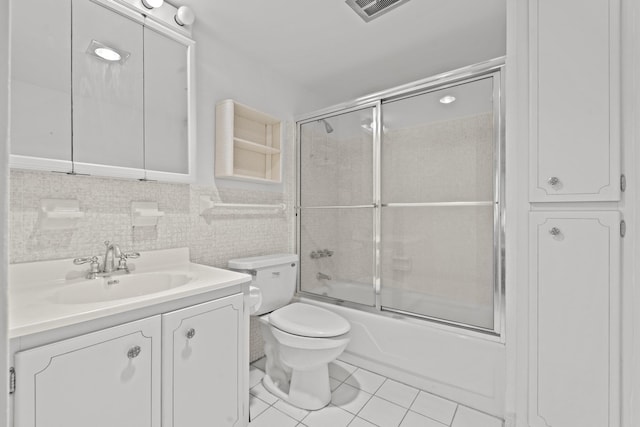 full bathroom with tile patterned flooring, backsplash, toilet, shower / bath combination with glass door, and vanity