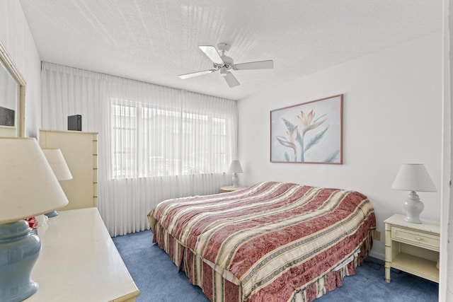 carpeted bedroom with ceiling fan and a textured ceiling