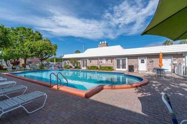 view of pool featuring central AC unit, a patio, and french doors