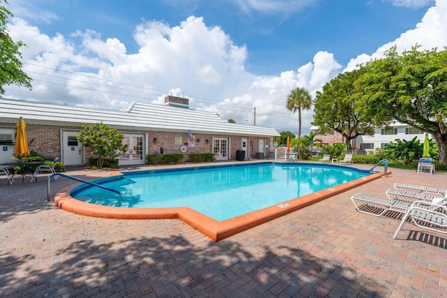 view of swimming pool featuring french doors and a patio area