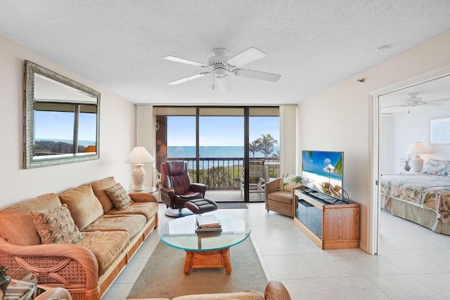 living room with ceiling fan, expansive windows, and a textured ceiling