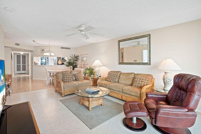 living room with light tile patterned flooring, a textured ceiling, and a notable chandelier