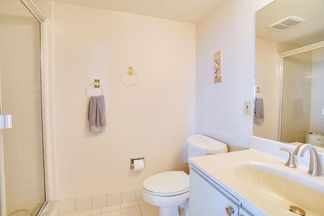 bathroom with toilet, vanity, tile patterned floors, and a shower with shower door