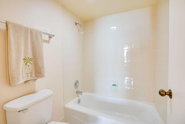 bathroom with tiled shower / bath combo and toilet