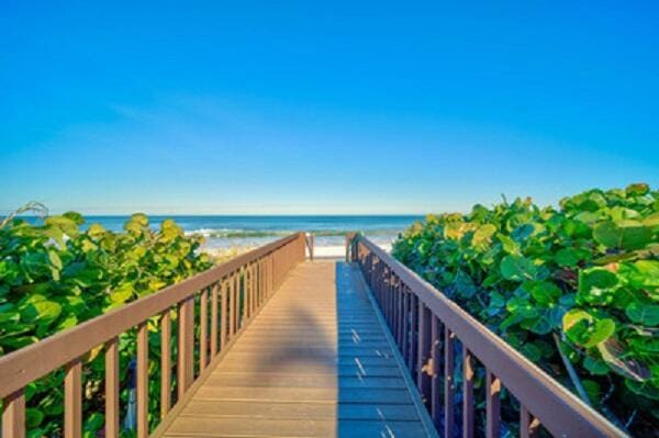 view of property's community featuring a water view and a beach view