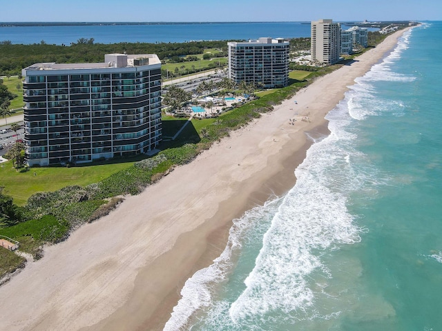 drone / aerial view featuring a water view and a view of the beach