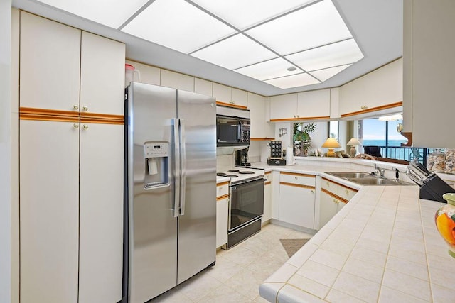 kitchen featuring kitchen peninsula, sink, white electric range, white cabinets, and stainless steel fridge with ice dispenser