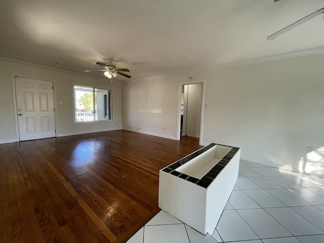 spare room featuring wood-type flooring, ceiling fan, and ornamental molding