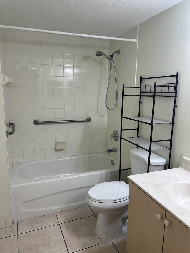 full bathroom with vanity, tiled shower / bath, tile patterned flooring, toilet, and a textured ceiling