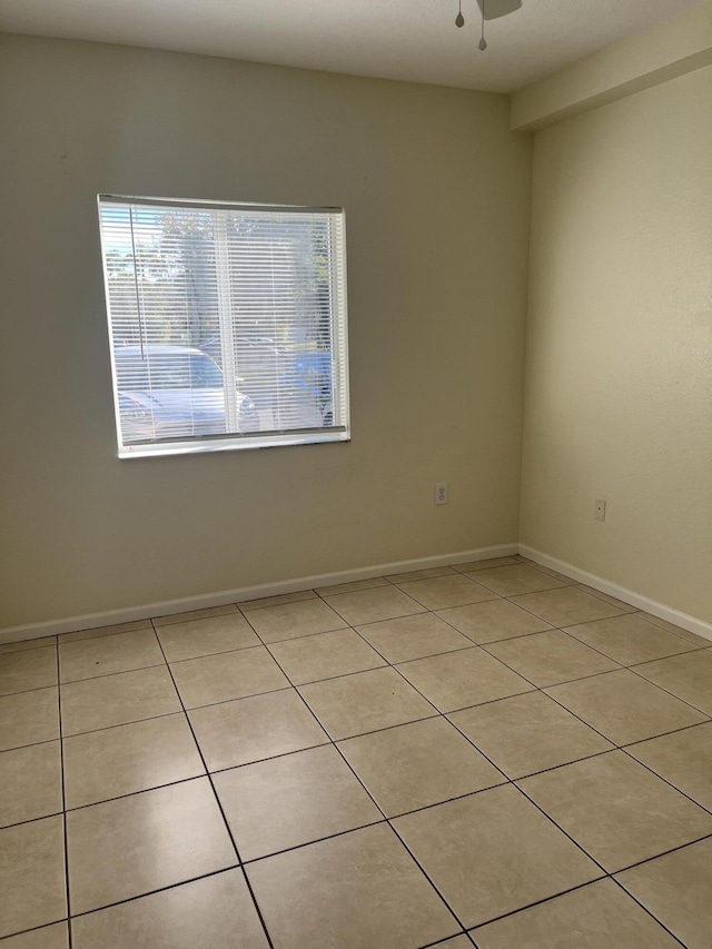 tiled spare room featuring ceiling fan and a healthy amount of sunlight