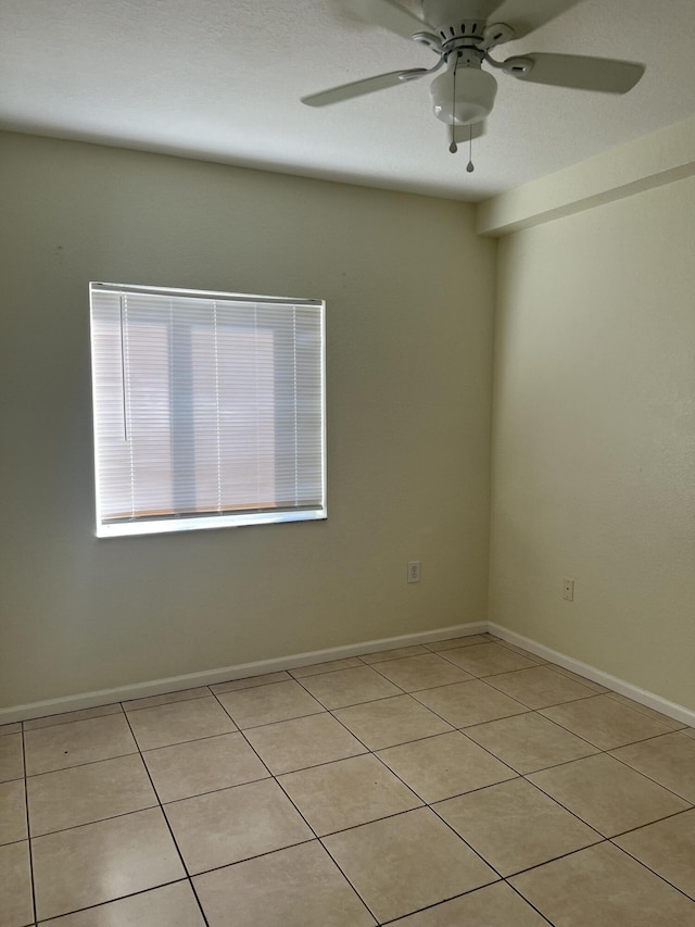 tiled empty room featuring ceiling fan