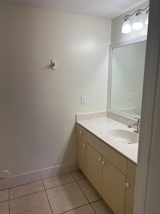 bathroom featuring tile patterned flooring, vanity, and a textured ceiling