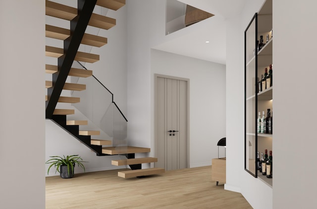 stairway featuring wood-type flooring and a high ceiling