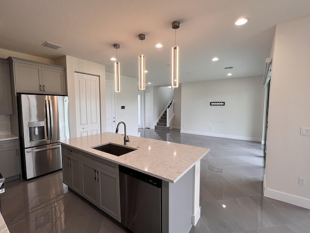 kitchen featuring gray cabinetry, pendant lighting, sink, light stone countertops, and appliances with stainless steel finishes