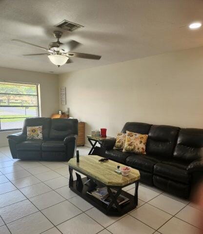 tiled living room with ceiling fan