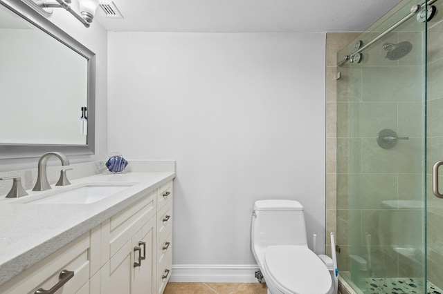 bathroom with tile patterned floors, vanity, toilet, and a shower with door