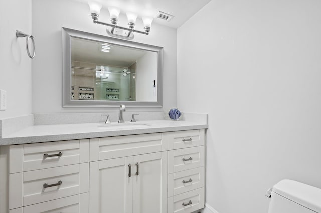 bathroom with vanity, an enclosed shower, and toilet