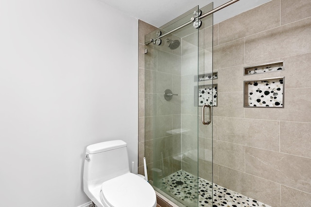 bathroom with a shower with shower door and toilet