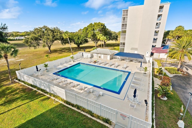 view of pool with a patio area and a lawn