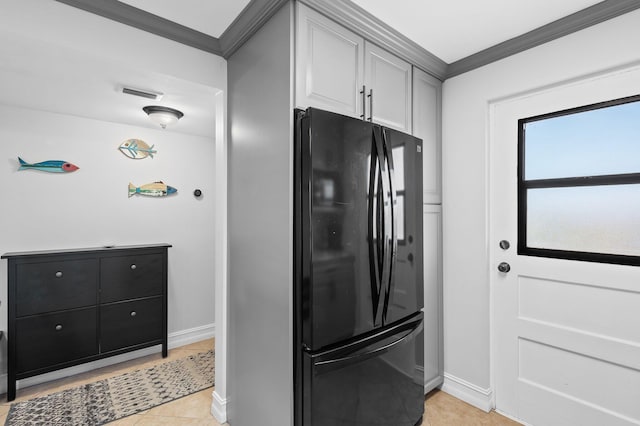 kitchen featuring ornamental molding, black refrigerator, white cabinets, and light tile patterned flooring