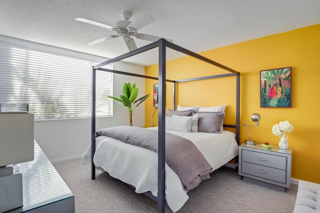 bedroom featuring a textured ceiling, light colored carpet, and ceiling fan