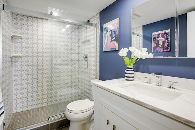 bathroom featuring vanity, toilet, and a shower with shower door