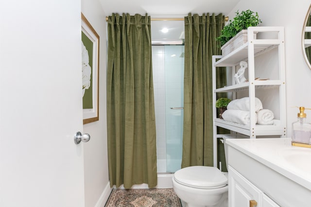 bathroom with an enclosed shower, vanity, and toilet