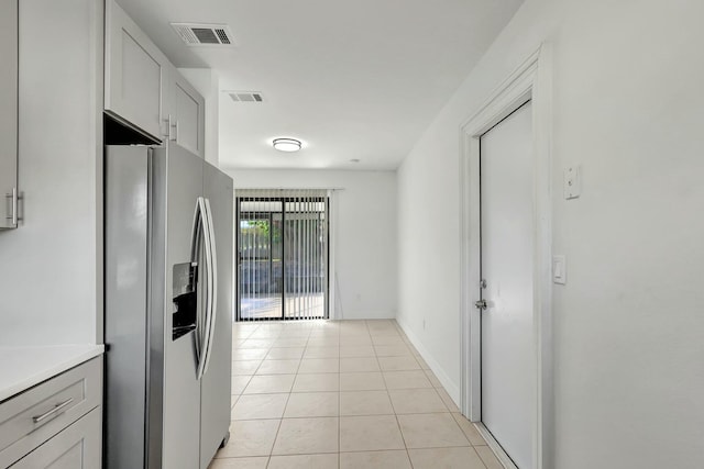 kitchen with stainless steel fridge and light tile patterned floors