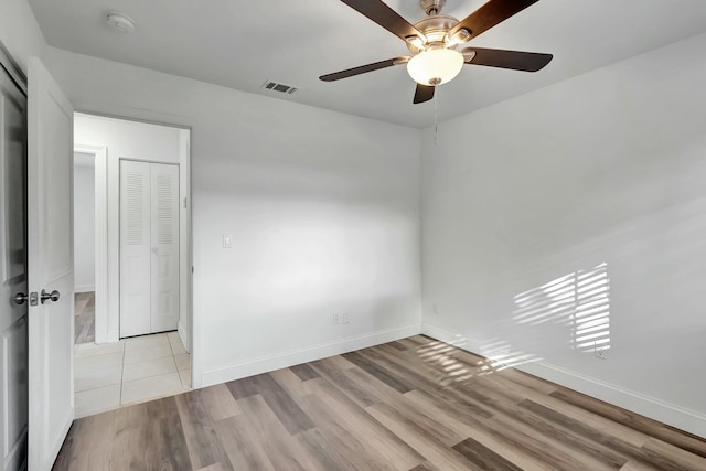 unfurnished room with light wood-type flooring and ceiling fan