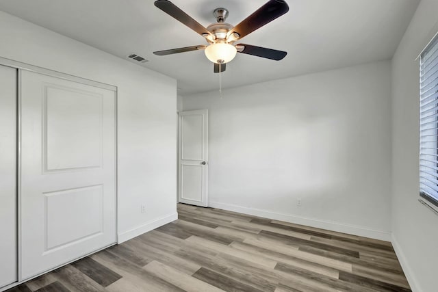 unfurnished bedroom with a closet, light hardwood / wood-style flooring, and ceiling fan