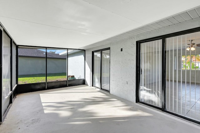 unfurnished sunroom with ceiling fan