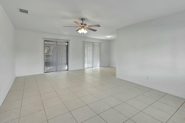 tiled spare room with ceiling fan