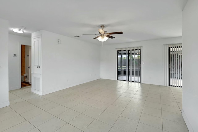 empty room with ceiling fan and light tile patterned floors