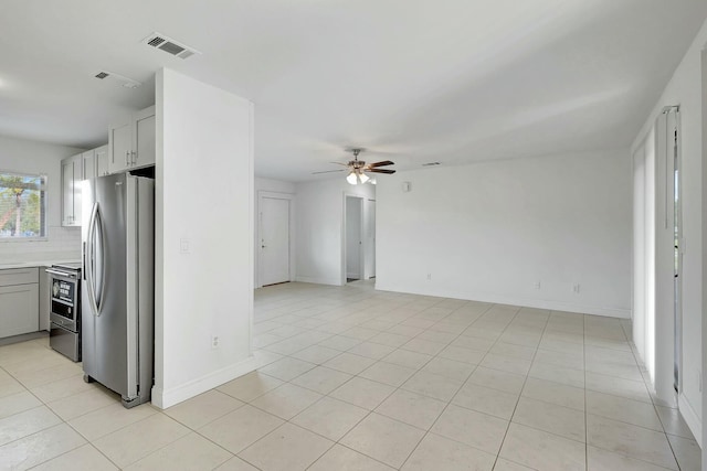 kitchen featuring ceiling fan, light tile patterned floors, appliances with stainless steel finishes, and tasteful backsplash