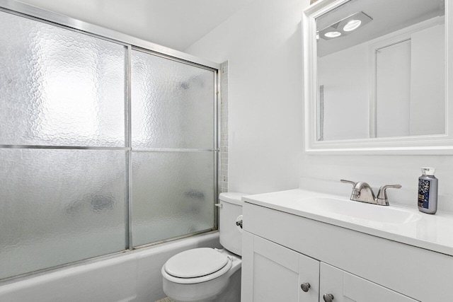 full bathroom featuring vanity, bath / shower combo with glass door, and toilet