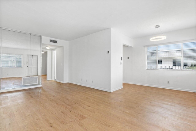 unfurnished living room with light wood-type flooring and plenty of natural light