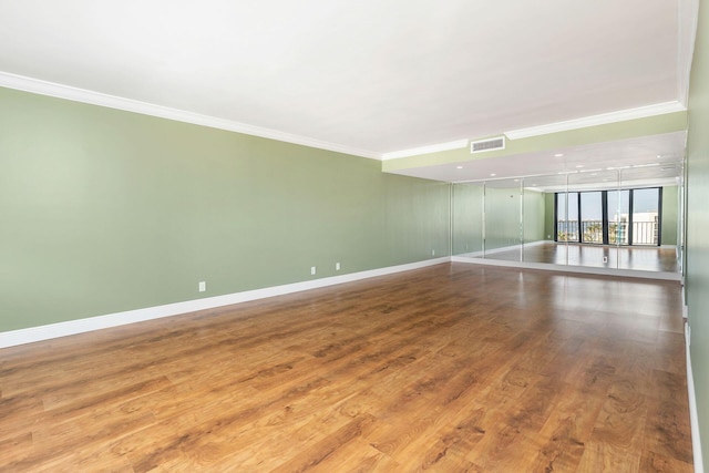 unfurnished room featuring wood-type flooring and ornamental molding