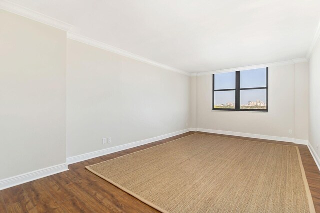 empty room with crown molding and dark wood-type flooring