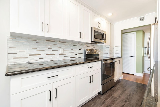 kitchen with backsplash, white cabinetry, dark stone counters, and appliances with stainless steel finishes