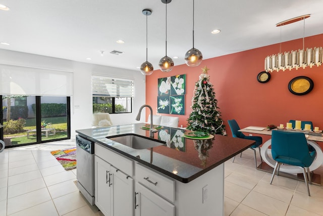 kitchen with white cabinetry, dishwasher, sink, hanging light fixtures, and a center island with sink