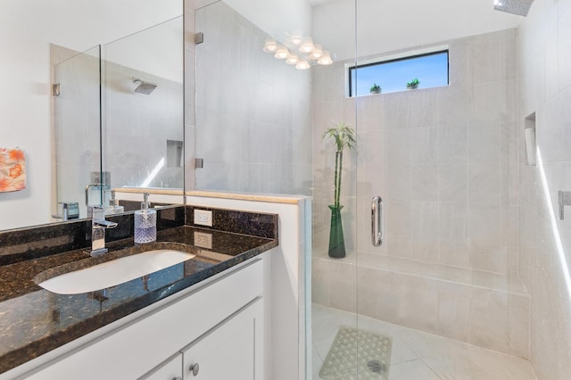 bathroom with a shower with door and vanity