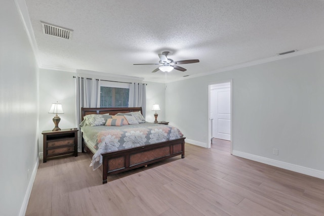 bedroom featuring a textured ceiling, ceiling fan, and crown molding