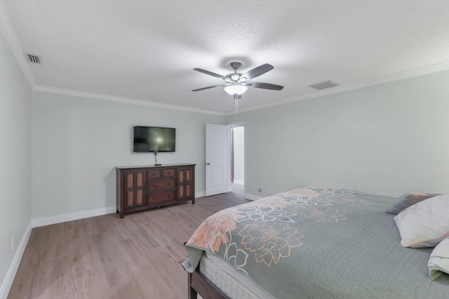 bedroom featuring ceiling fan, crown molding, a textured ceiling, and light hardwood / wood-style flooring