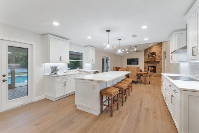 kitchen featuring decorative backsplash, sink, white cabinets, and a kitchen island