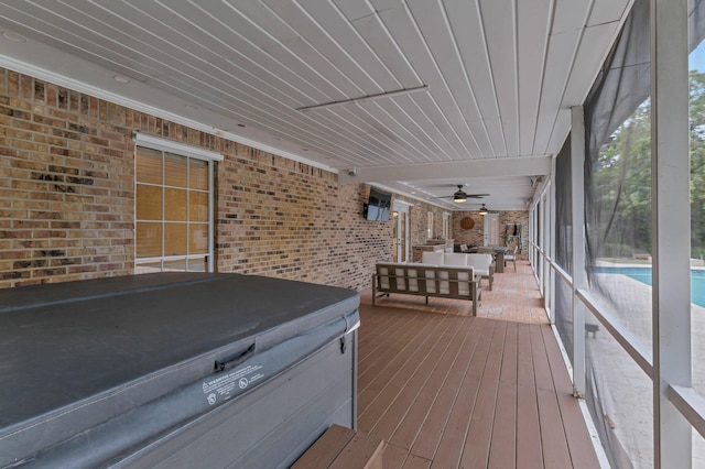 wooden terrace featuring outdoor lounge area, a patio, and a hot tub