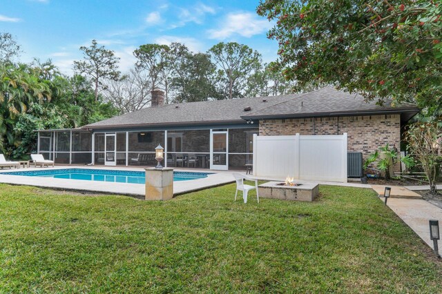 exterior space with a sunroom, an outdoor fire pit, and a lawn