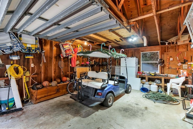 garage featuring a workshop area and white refrigerator